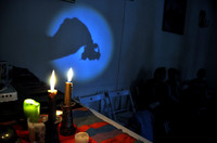 zdjęcie na którym widać, jak uczestnik warsztatów odczytuje wróżbe z cienia odbitego na ścianie