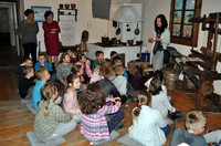 dzieci w izbie zagłębiowskiej słuchające o zwyczajach andrzejkowych